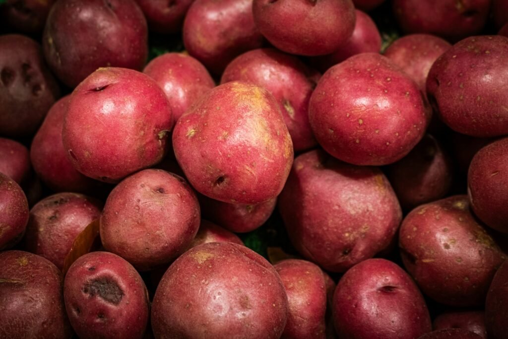 Fresh red potatoes are piled together for sale.